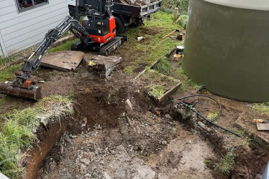 Mini excavator working in a tight space behind a Waikato house